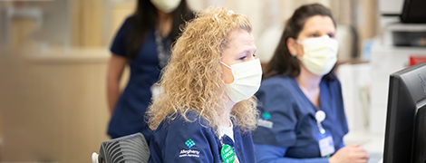 image of a nurse with mask on a computer