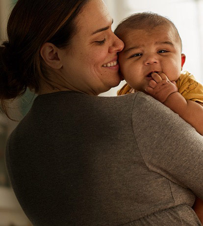  photo of a smiling woman holding a baby